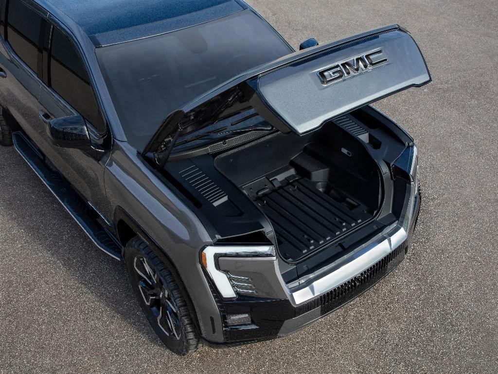 The GMC Sierra EV Denali Edition 1 with the power-operated hood open, showcasing the storage in the front eTrunk.