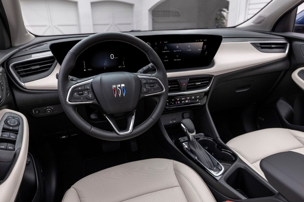 View of the driver’s seat in 2024 Buick Encore GX Avenir with Whisper Beige and Jet Black interior.