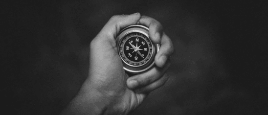 Hand holding a compass