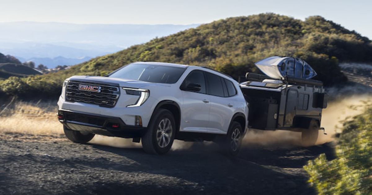 GMC acadia towing a trailer with a kayak on top