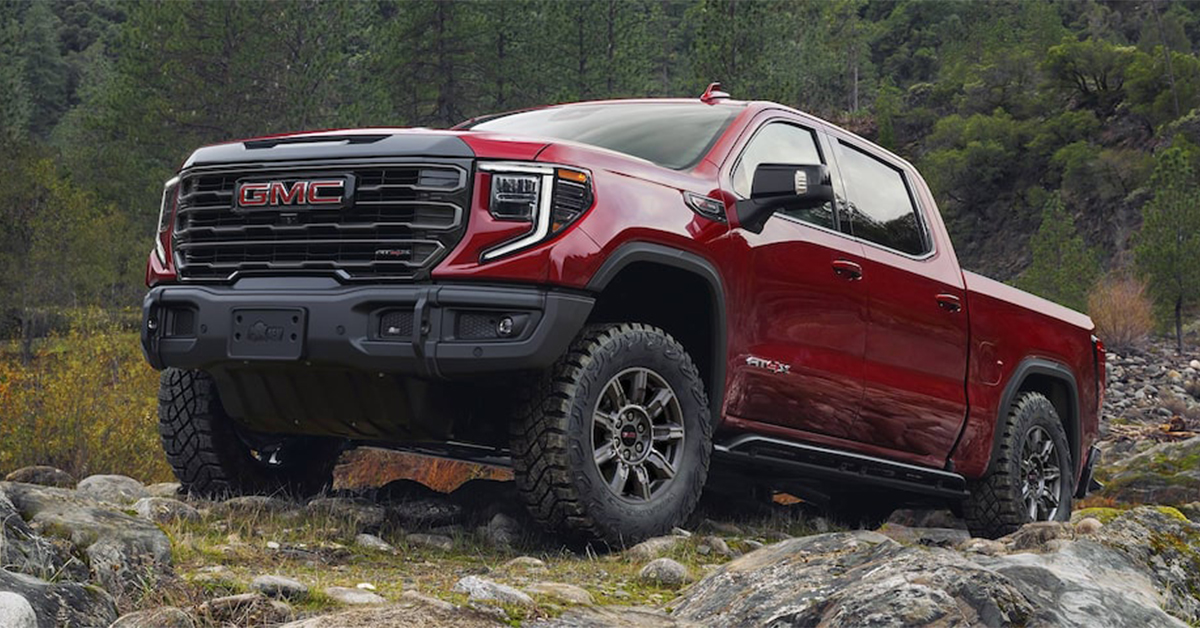 2025 GMC Sierra 1500 climbing up a grassy hill with rocks on it