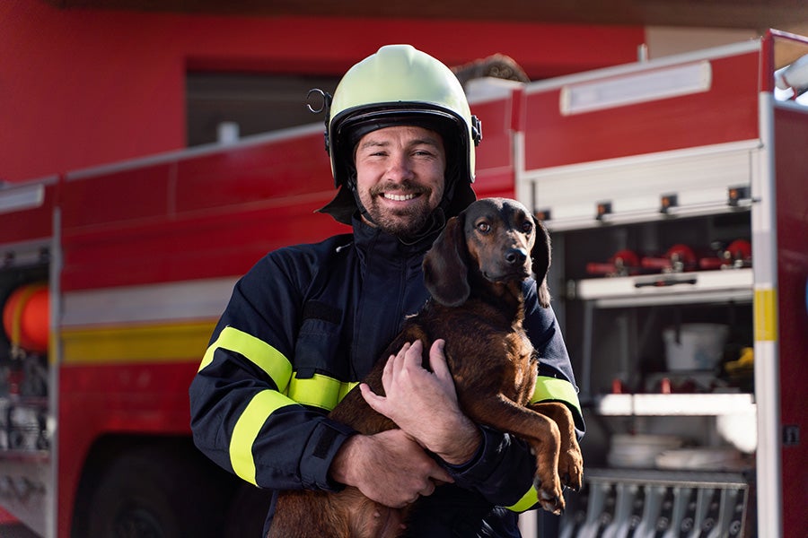 Firefighter holding puppy