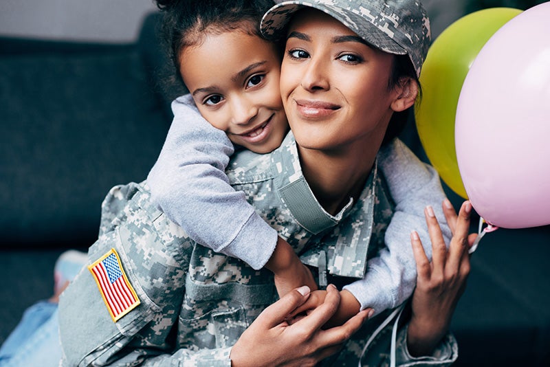 Daughter hugging military mother